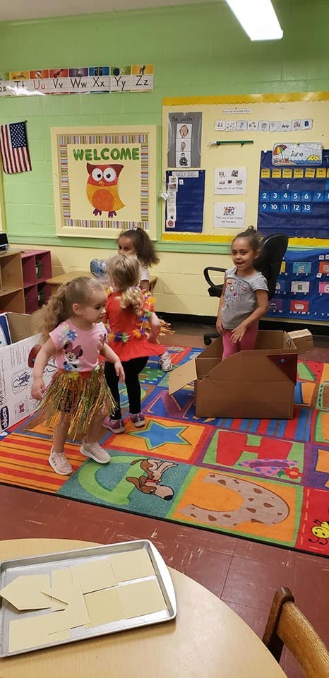 Three children playing in a classroom