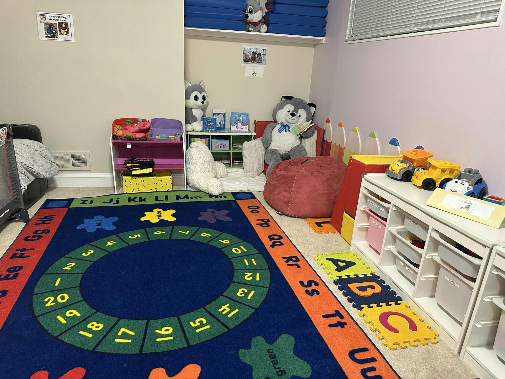 Playroom with a blue rug, toys, and a red beanbag chair