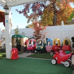 Toy cars and ride-on toys on artificial grass