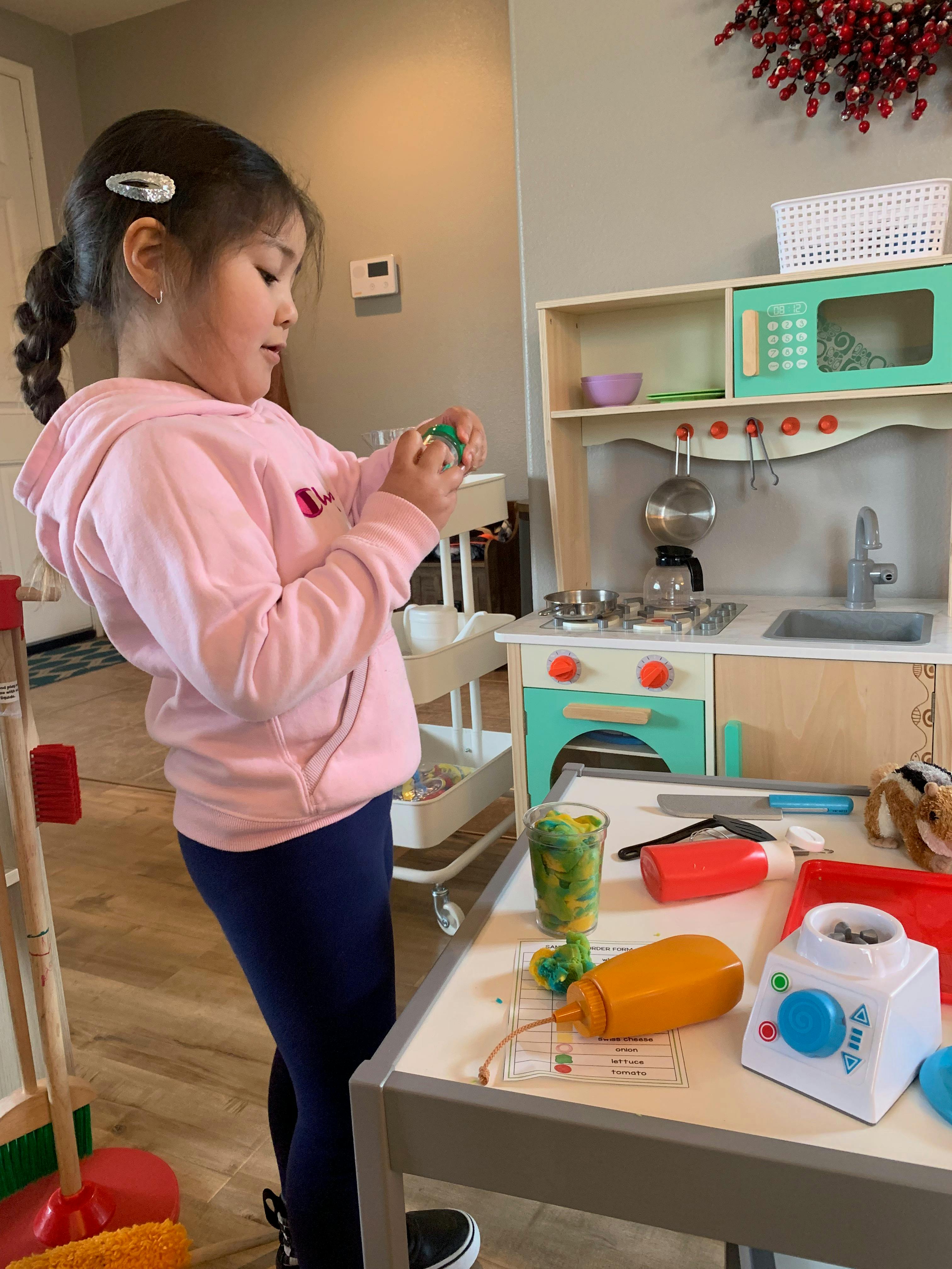 Child playing with toy kitchen set