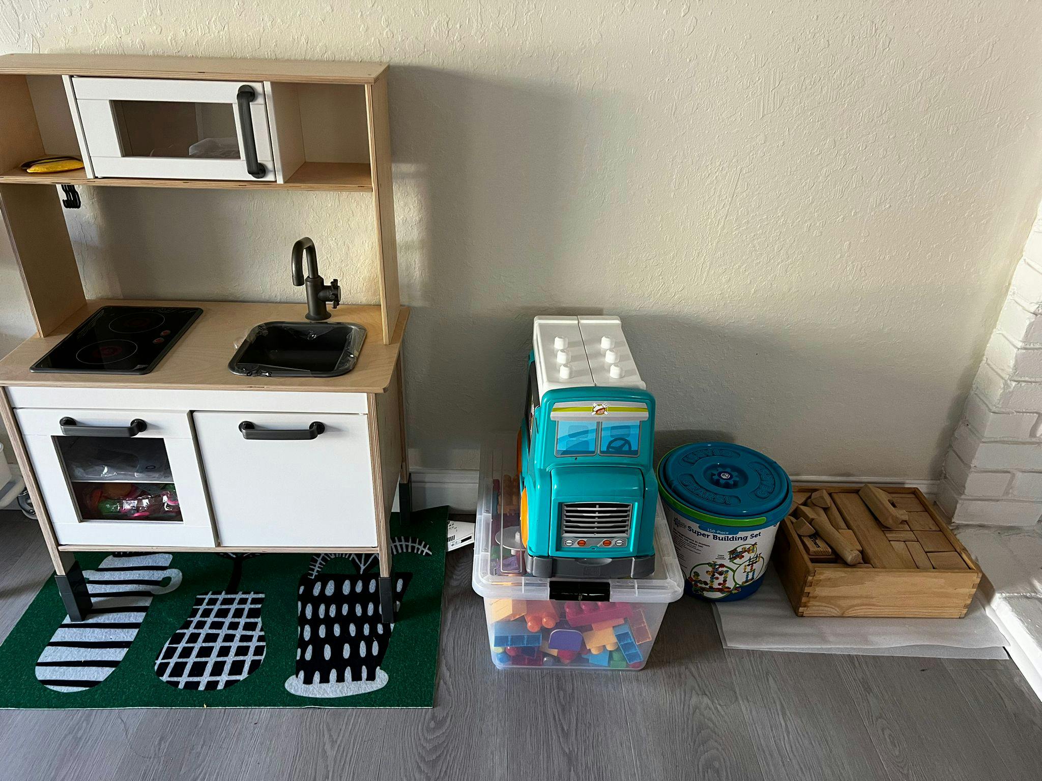 Toy kitchen set with a toy truck and other toys next to it