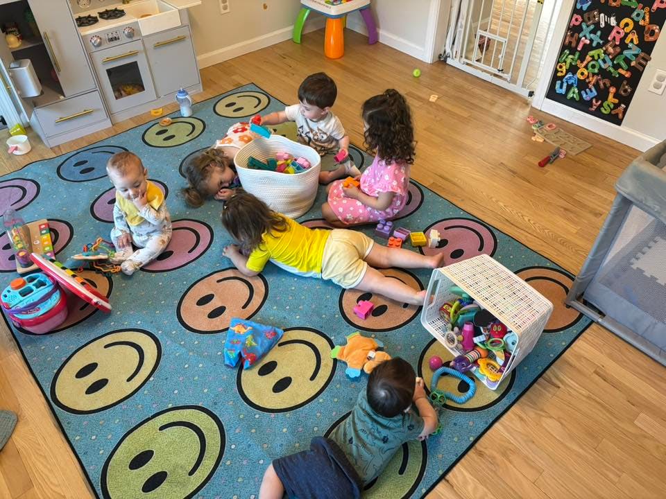 Multiple children playing with toys on a rug