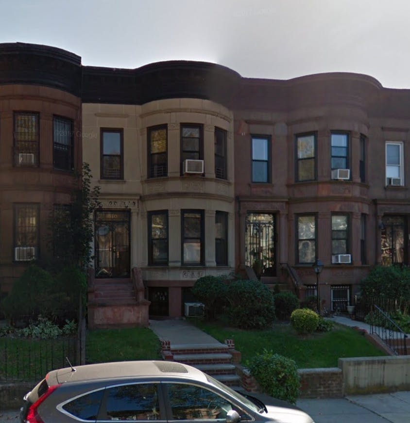 Row of brownstone buildings with a car in the foreground