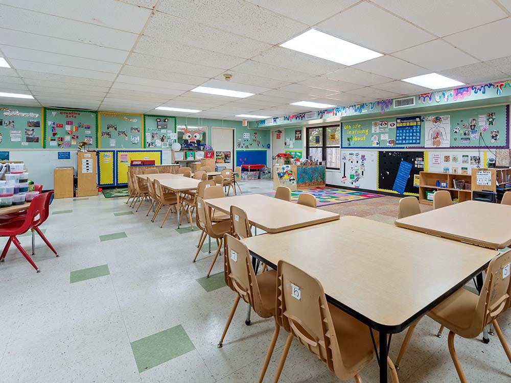 Empty classroom with small tables and chairs