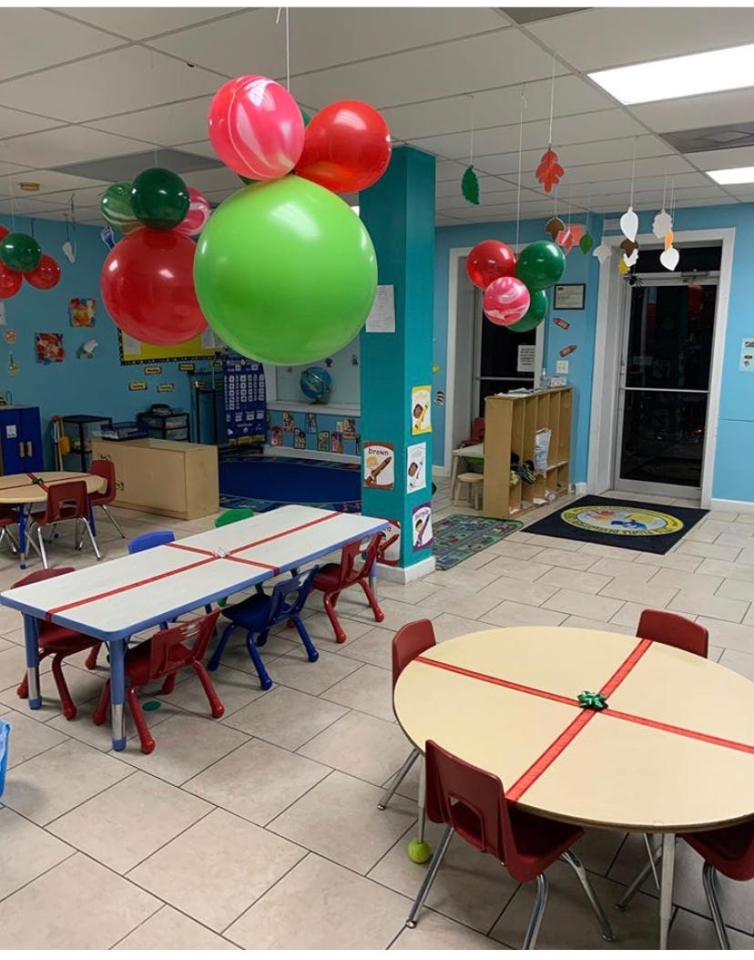 Classroom with tables and chairs, balloons hanging from the ceiling