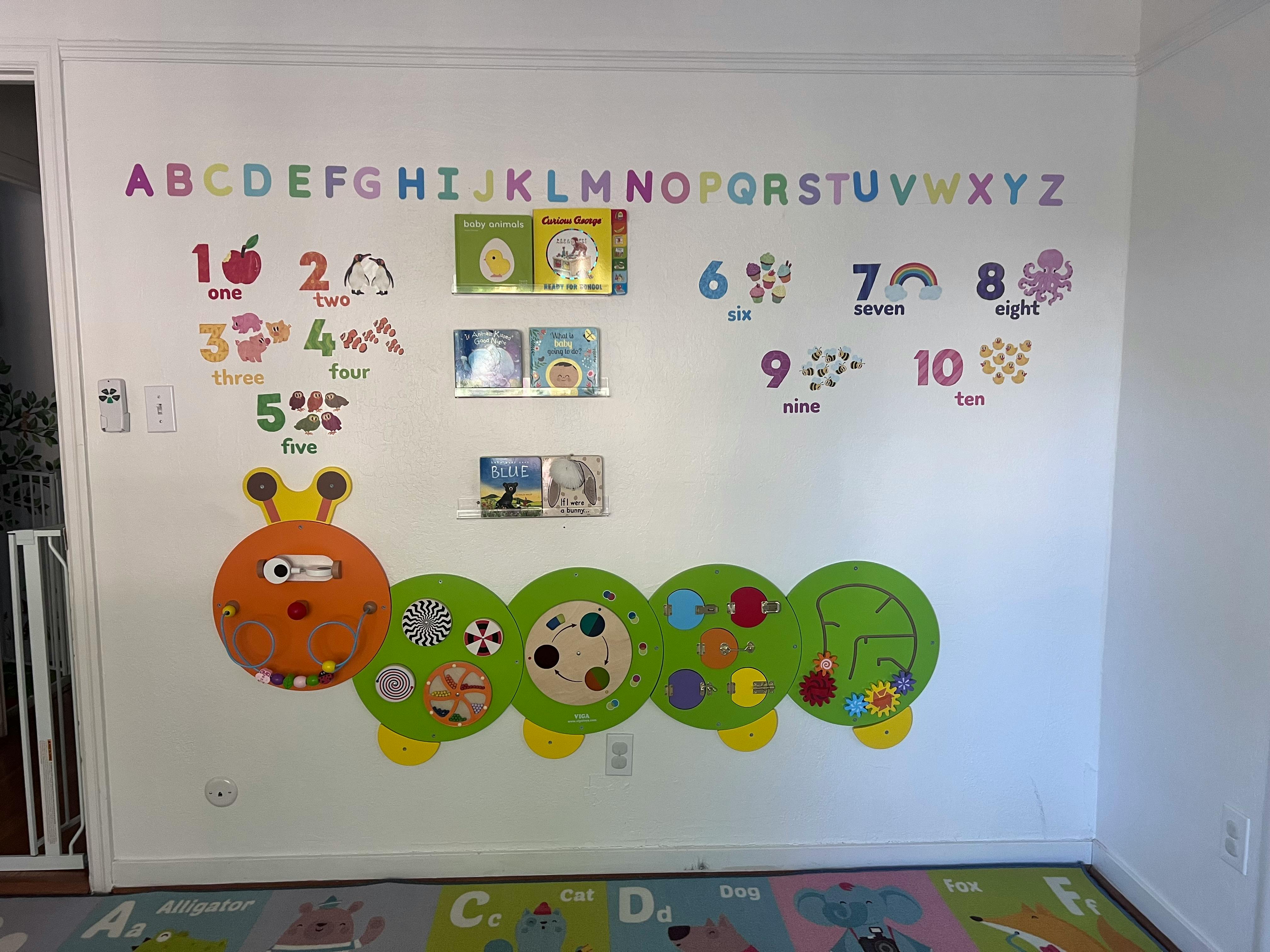 Wall decorated with alphabet letters, numbers, and a caterpillar toy