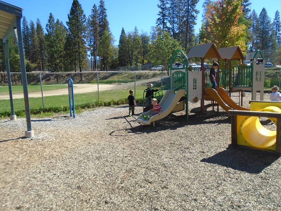 Children playing on a playground with slides and climbing structures