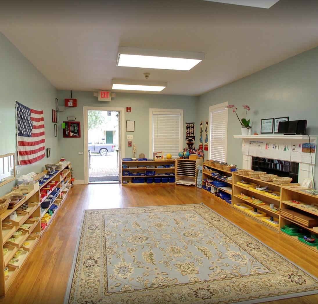 Classroom with shelves of learning materials, a rug, and an American flag