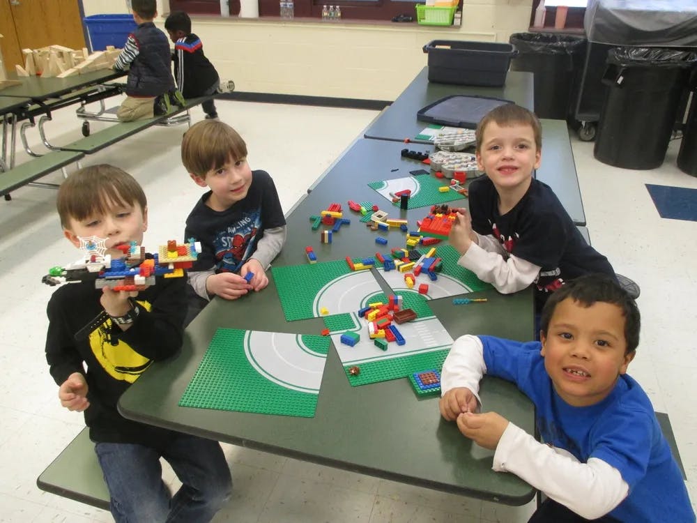 Four children playing with building blocks at a table