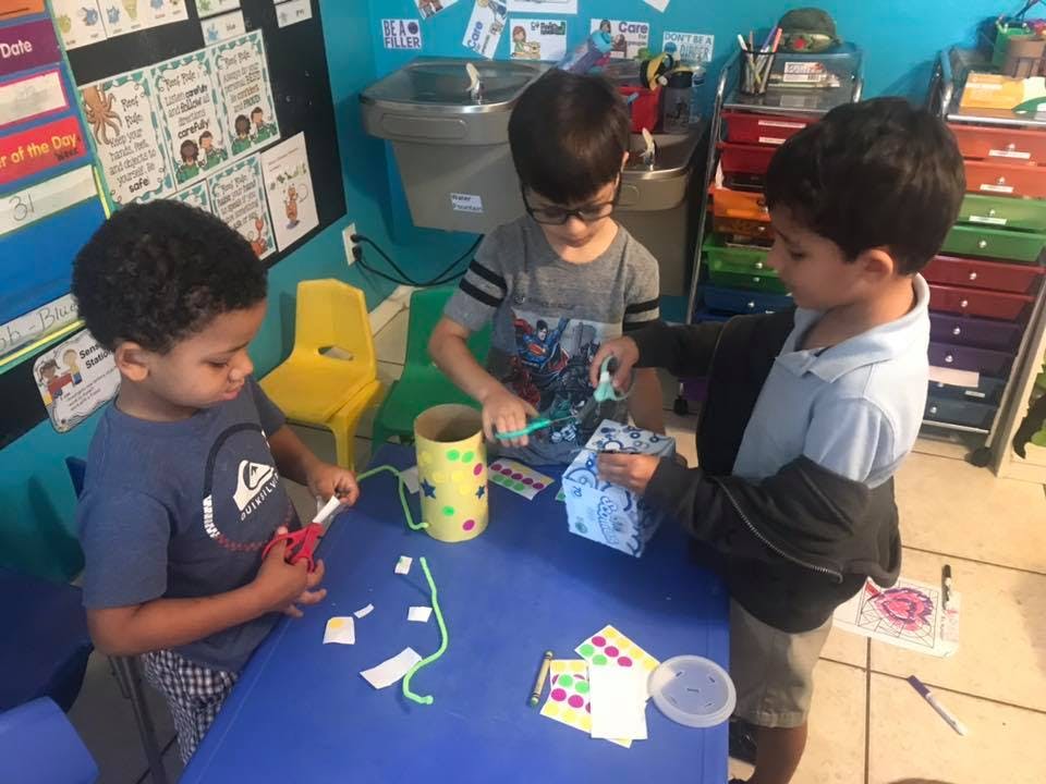 Three children doing crafts at a table
