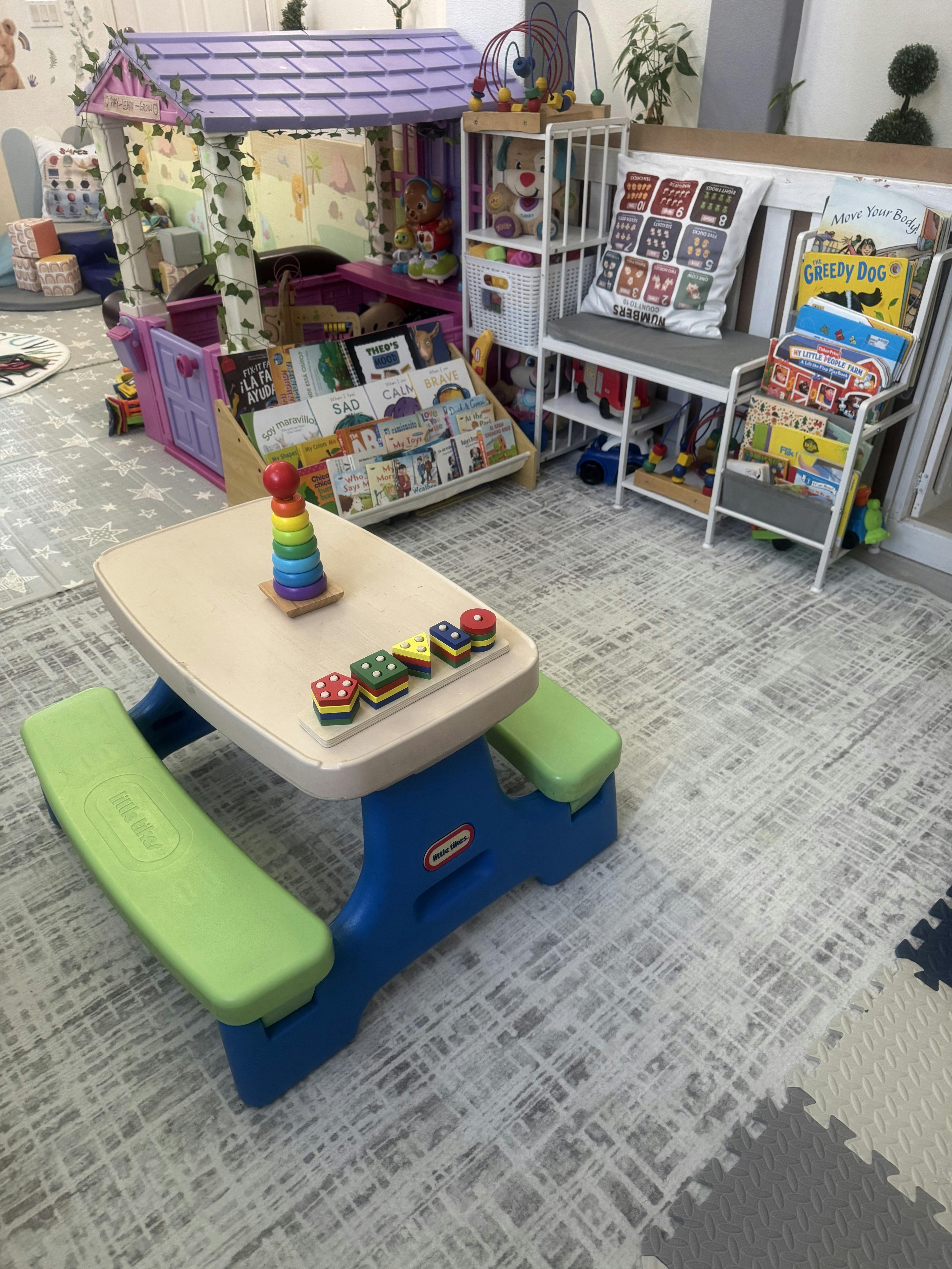 Small plastic table with wooden stacking toys in a children's play area