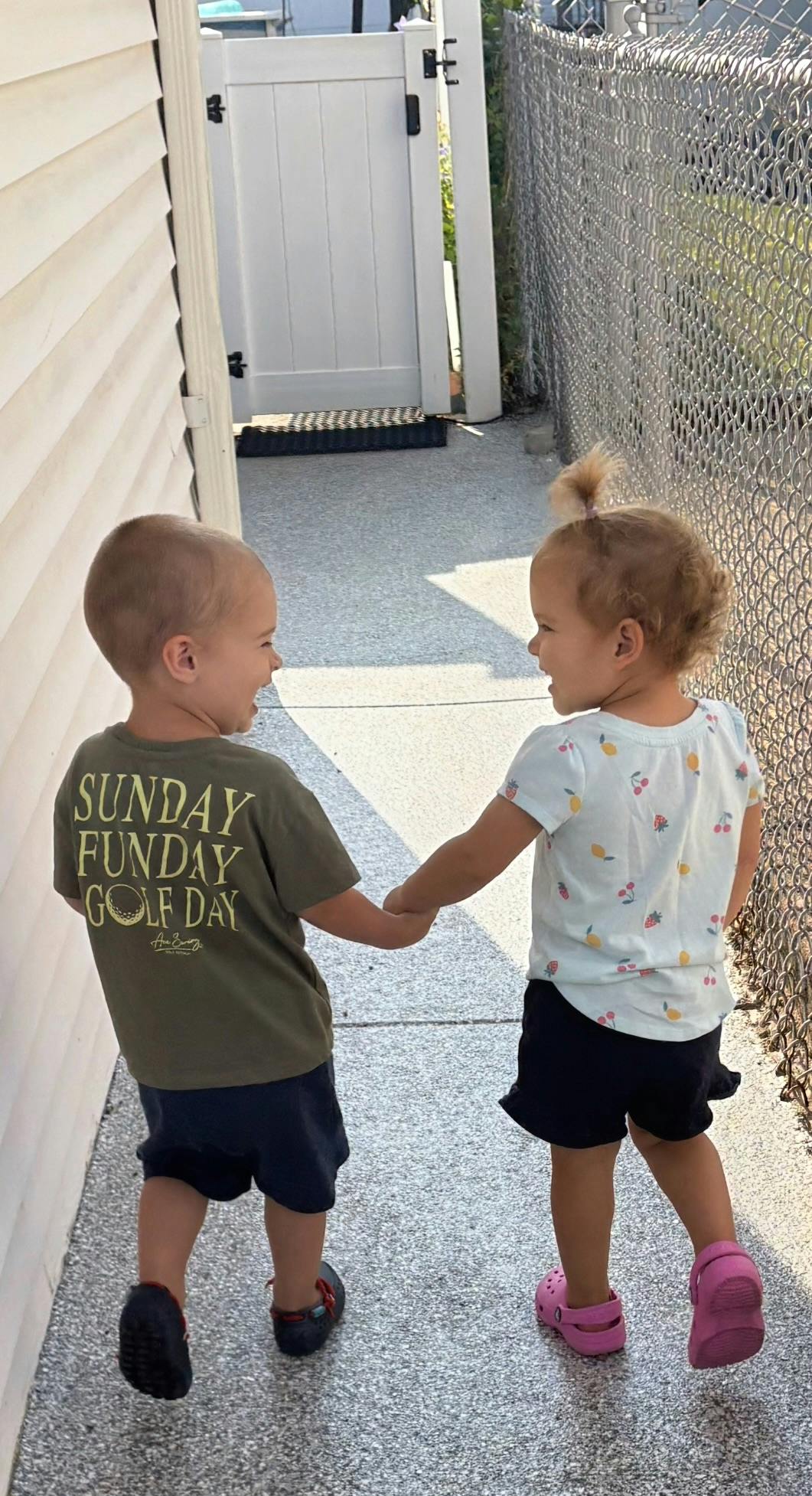 Two children holding hands and walking