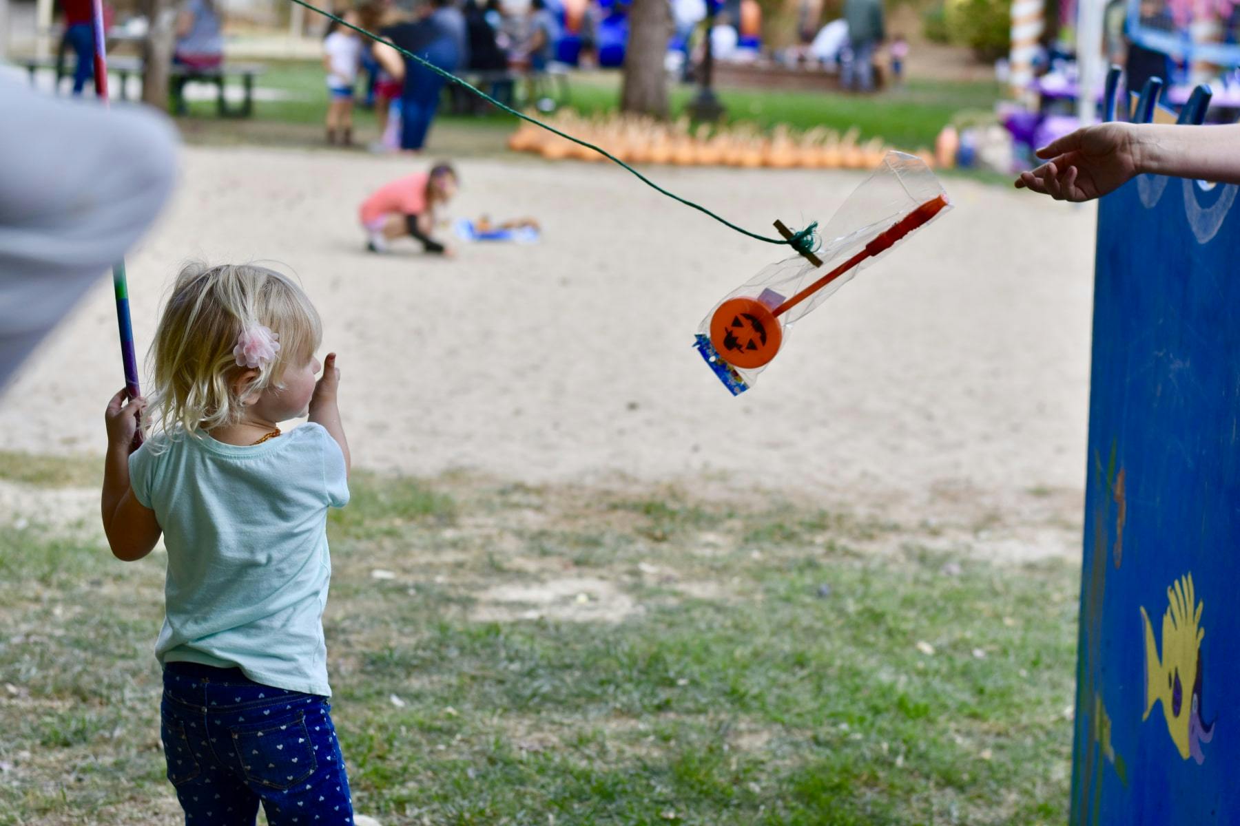 Child playing a fishing game outdoors