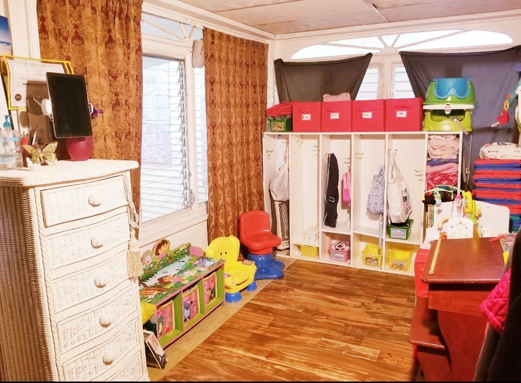 Room with dresser, window, and storage units with children's items