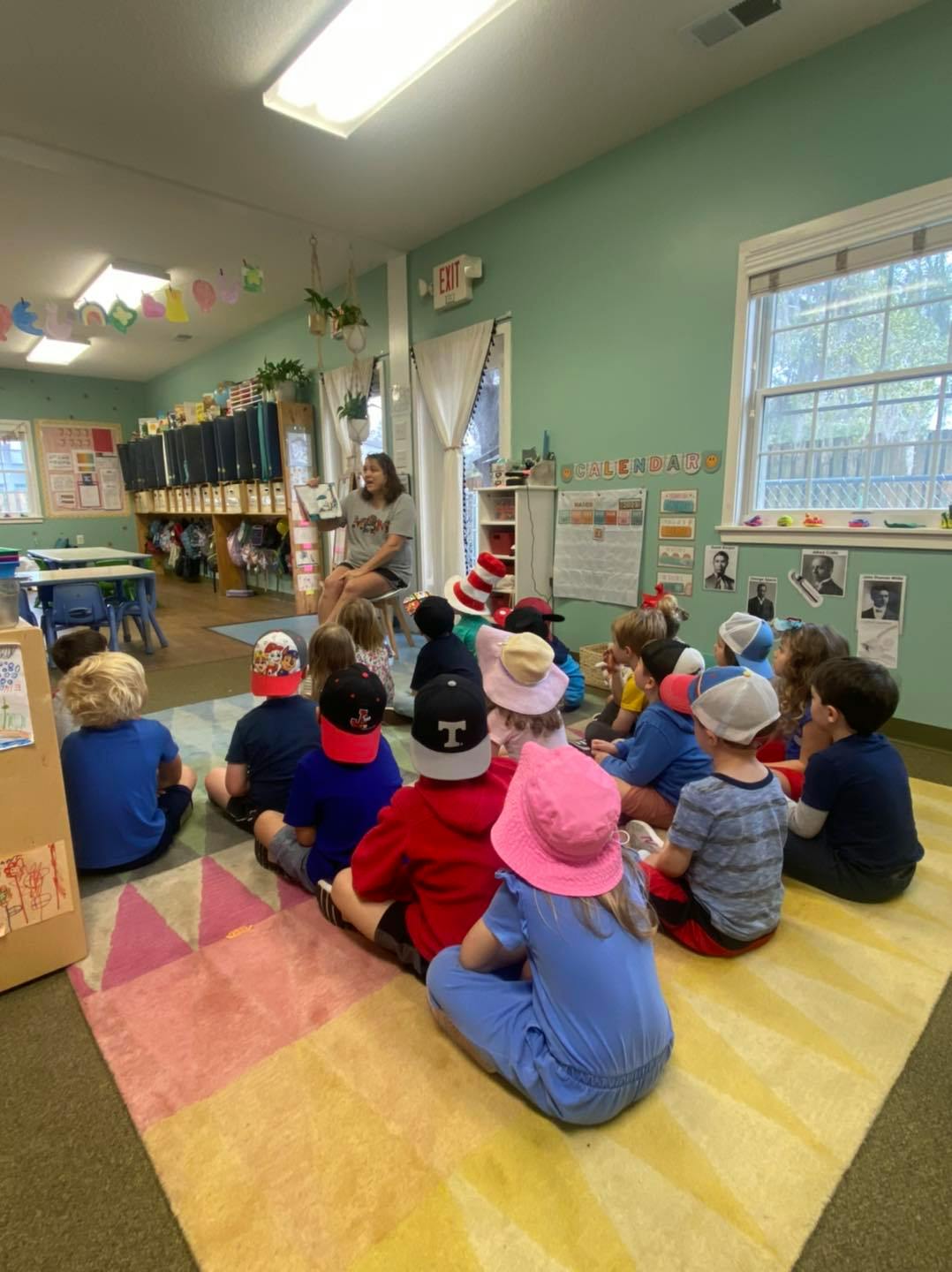 Person reading to a group of children in a classroom