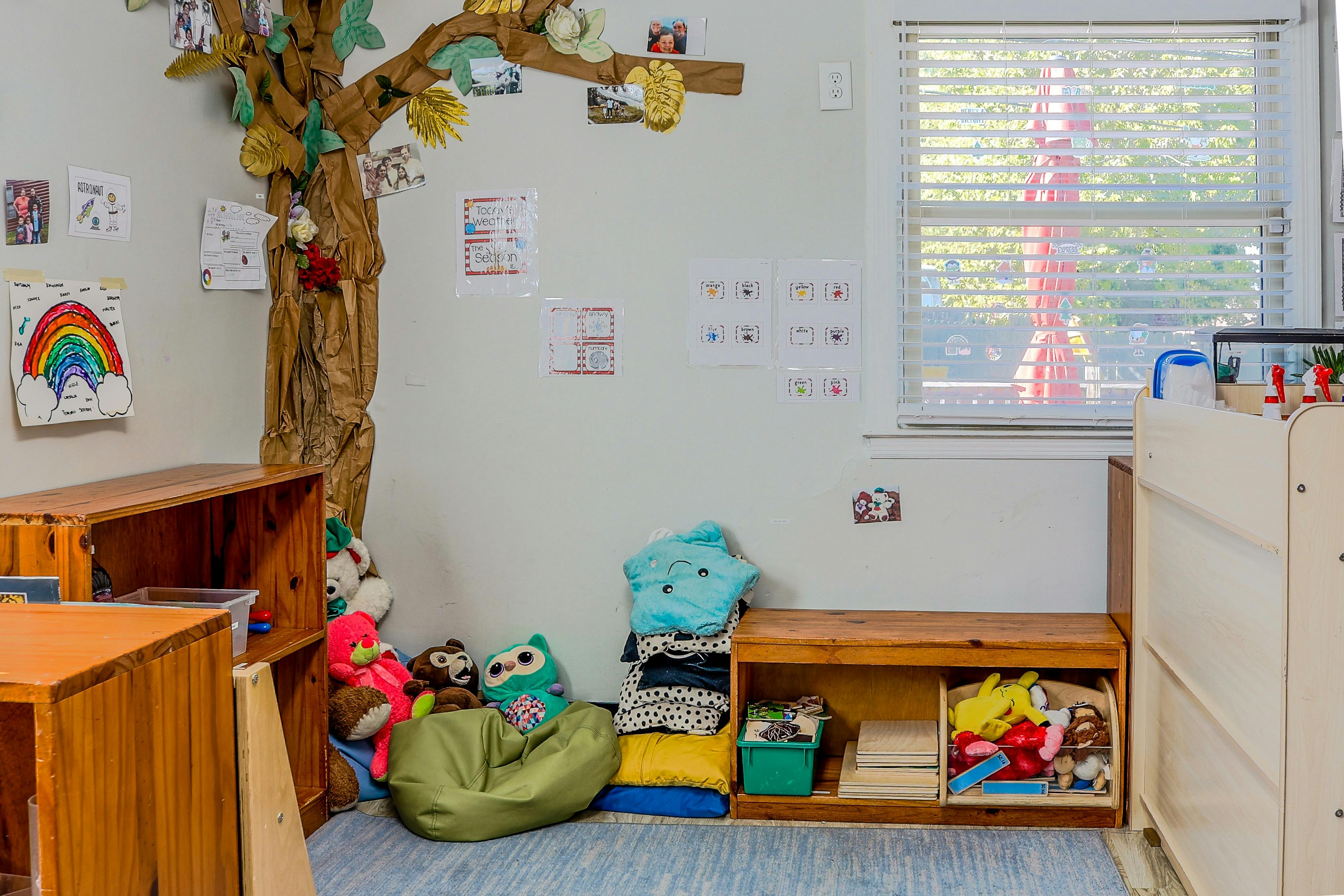 Classroom corner with shelves, stuffed toys, and educational wall displays