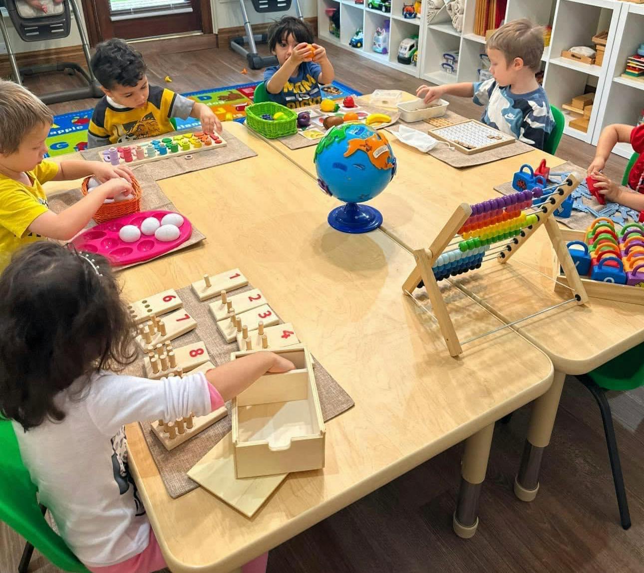 Children at a table playing with educational toys in a classroom