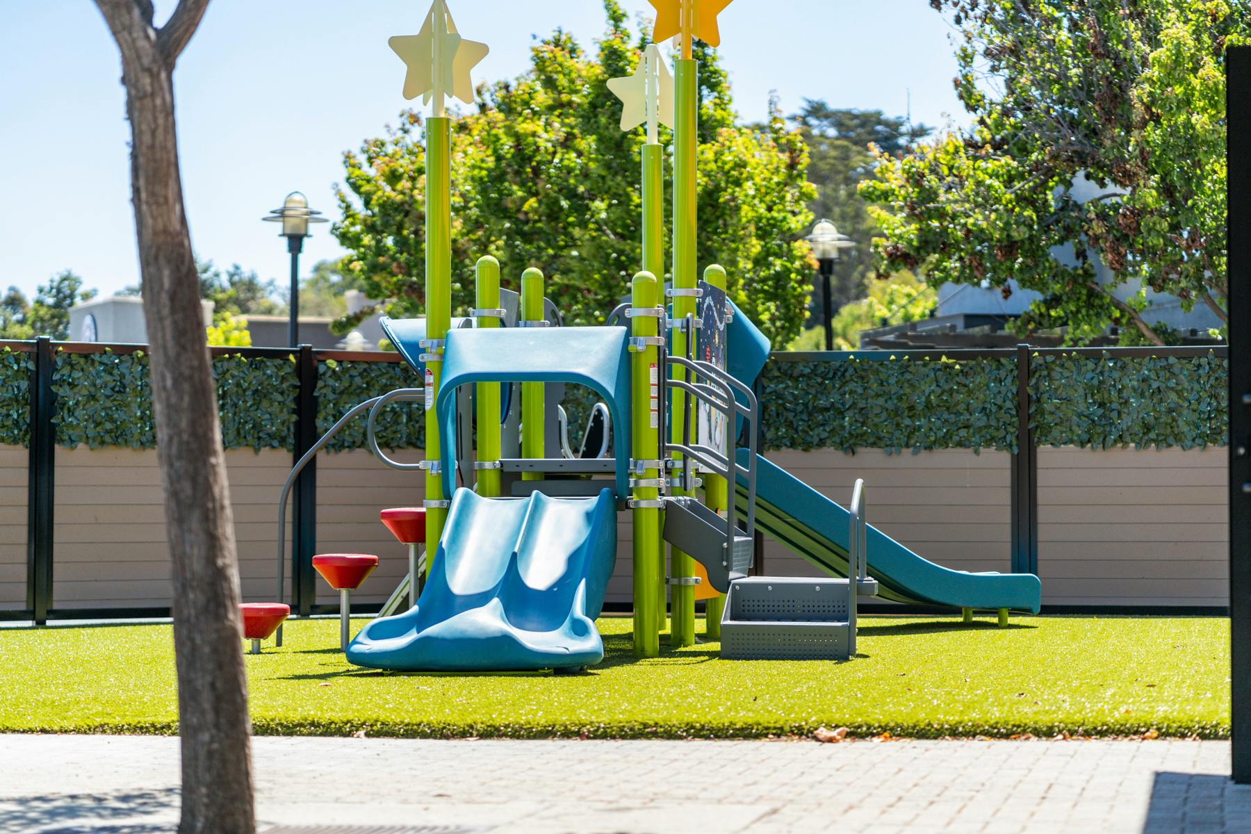 Playground with blue slides and climbing structures on green turf