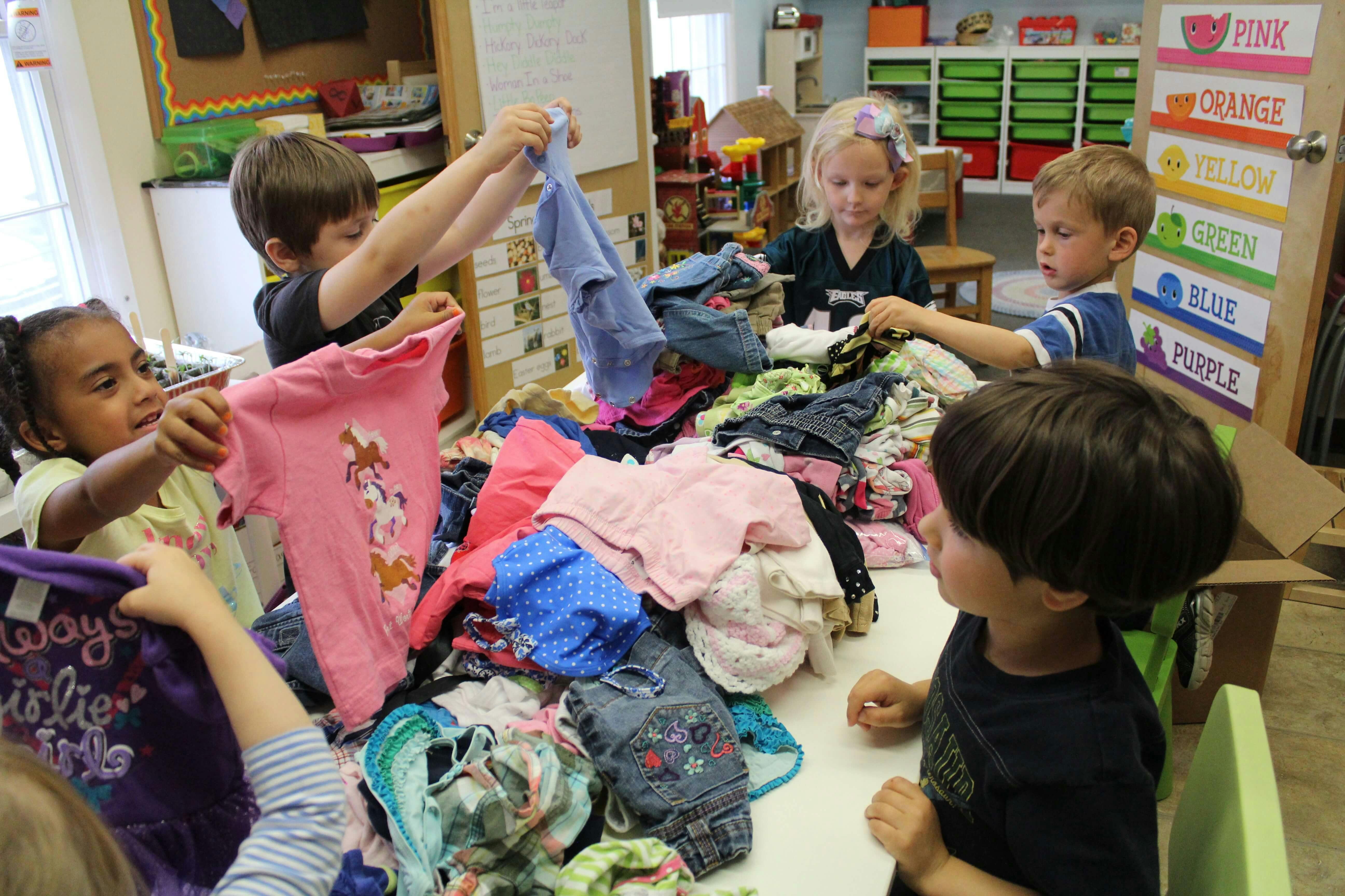Children sorting clothes in a classroom