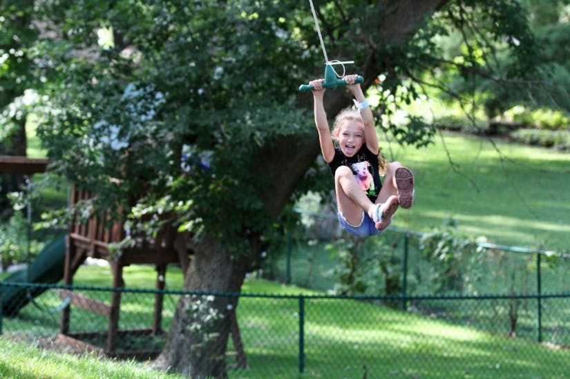 Child on a zip line in a backyard