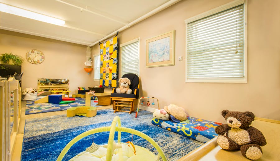 Child's playroom with toys, small bed, and rocking chair