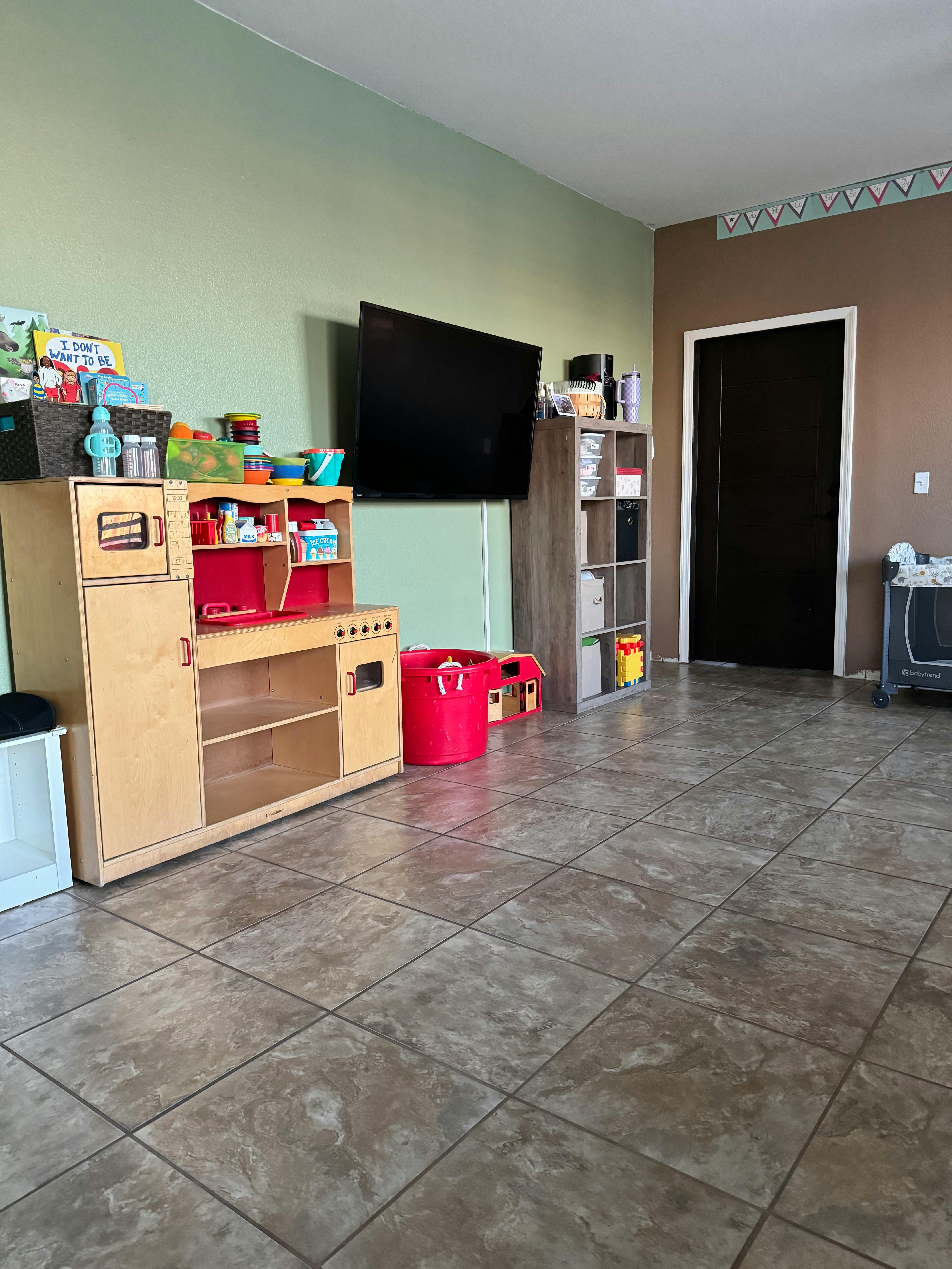 Play kitchen and storage shelves in a room with a television