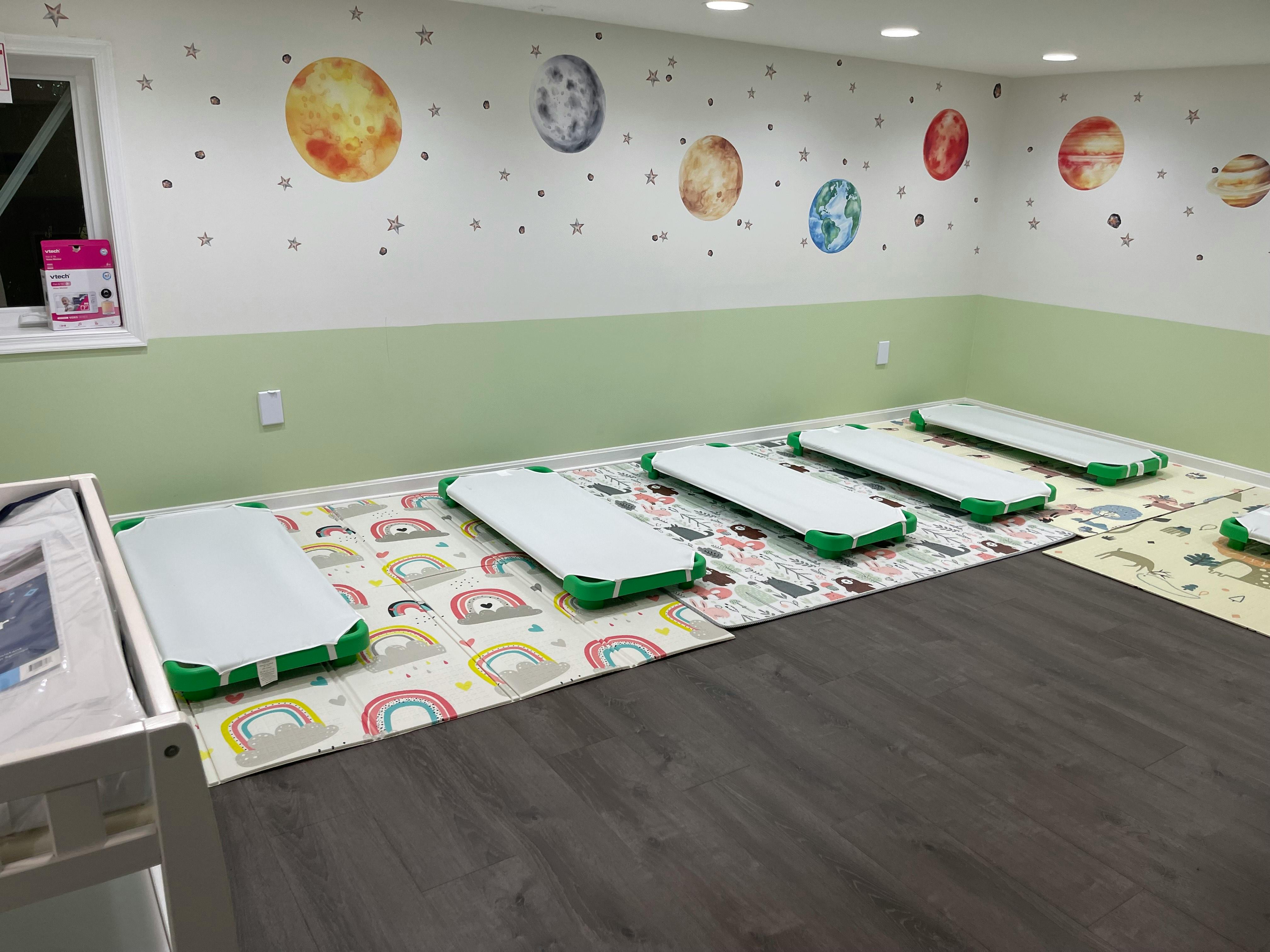 Room with planet wall decals and several floor mats
