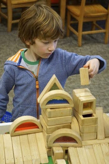Child playing with wooden building blocks