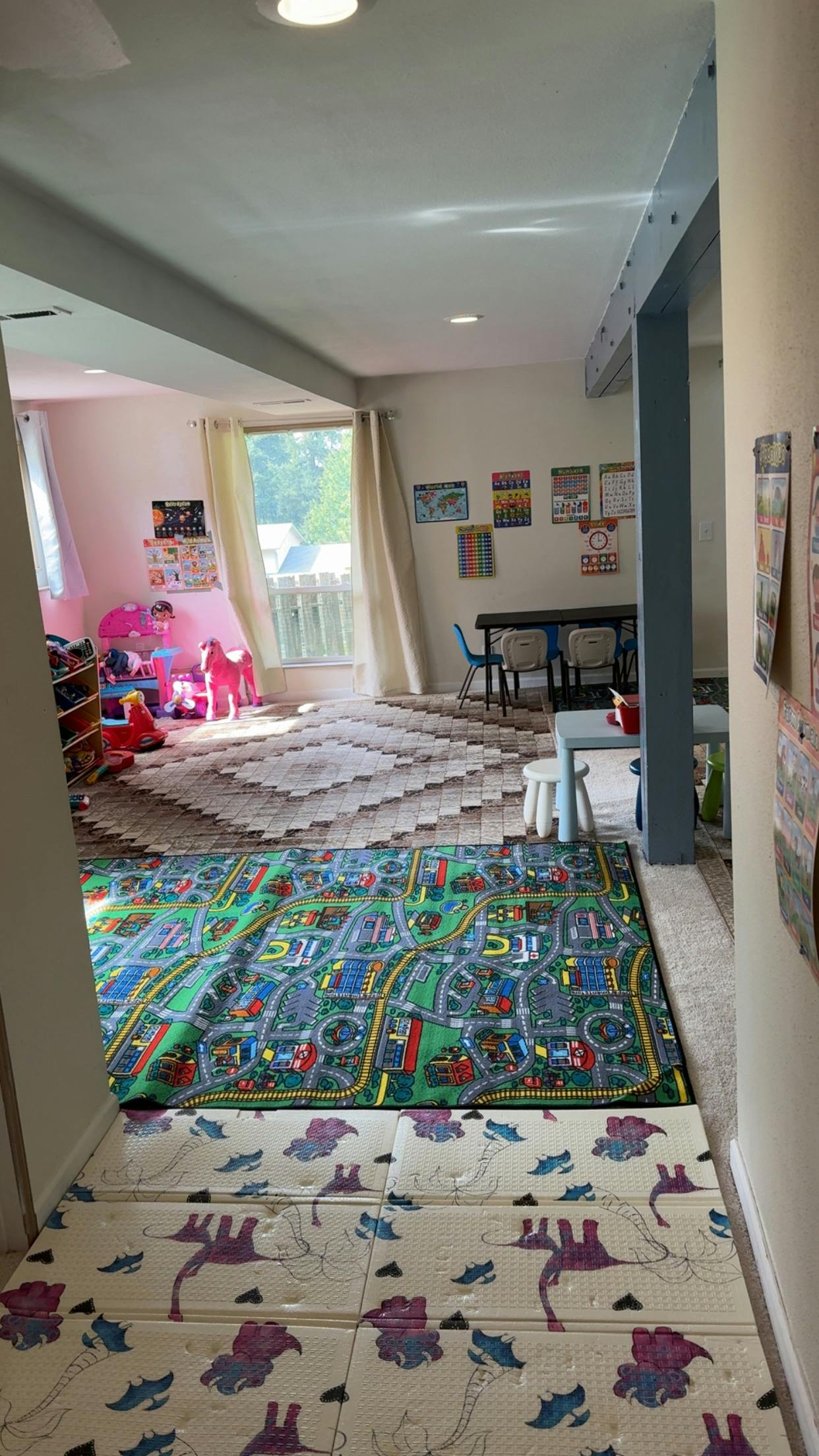 Playroom with various play mats and a small table and chairs