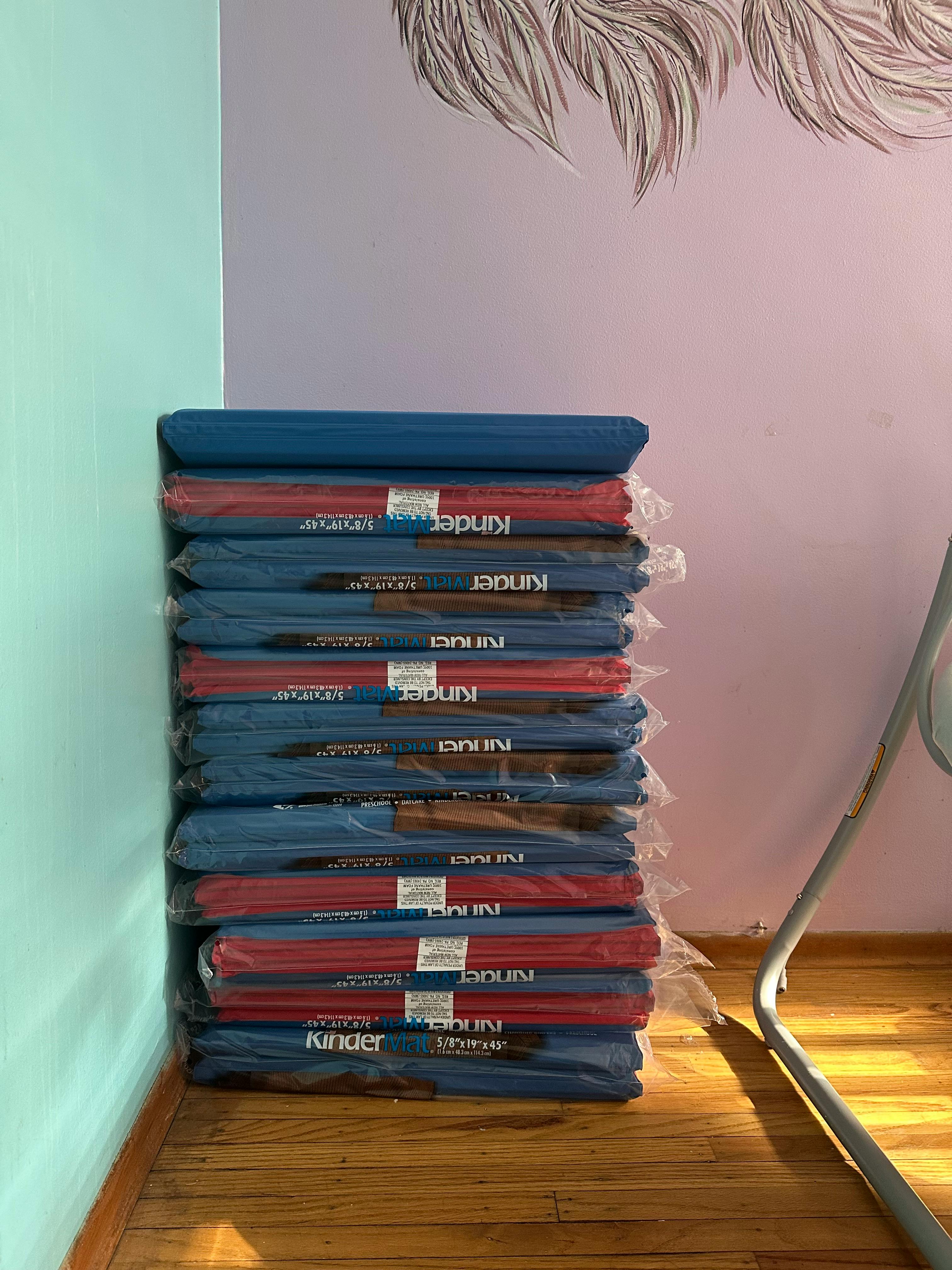 Stack of blue and red mats wrapped in plastic