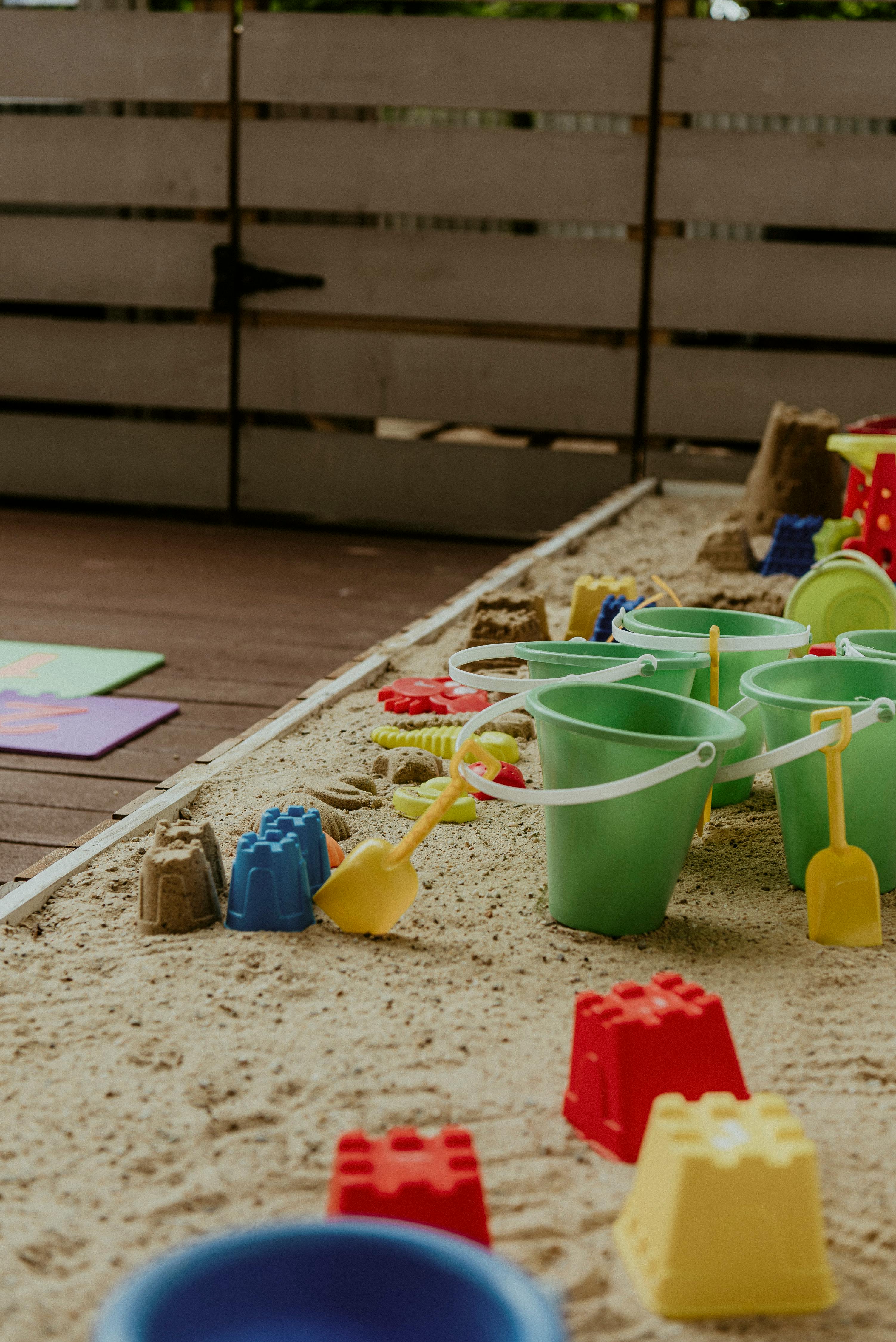 Sandpit with buckets, shovels, and sand molds
