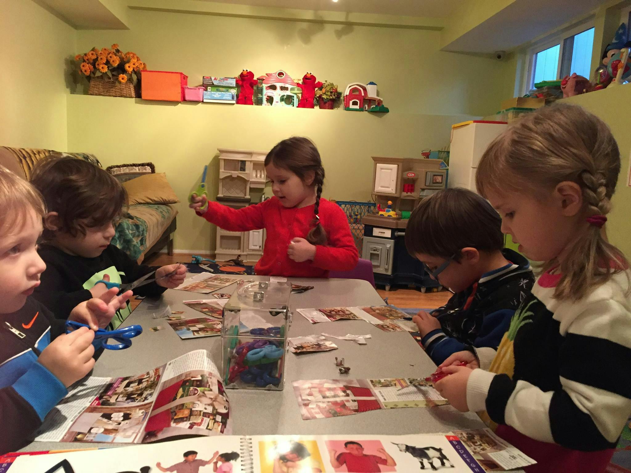 Four children sitting at a table doing crafts