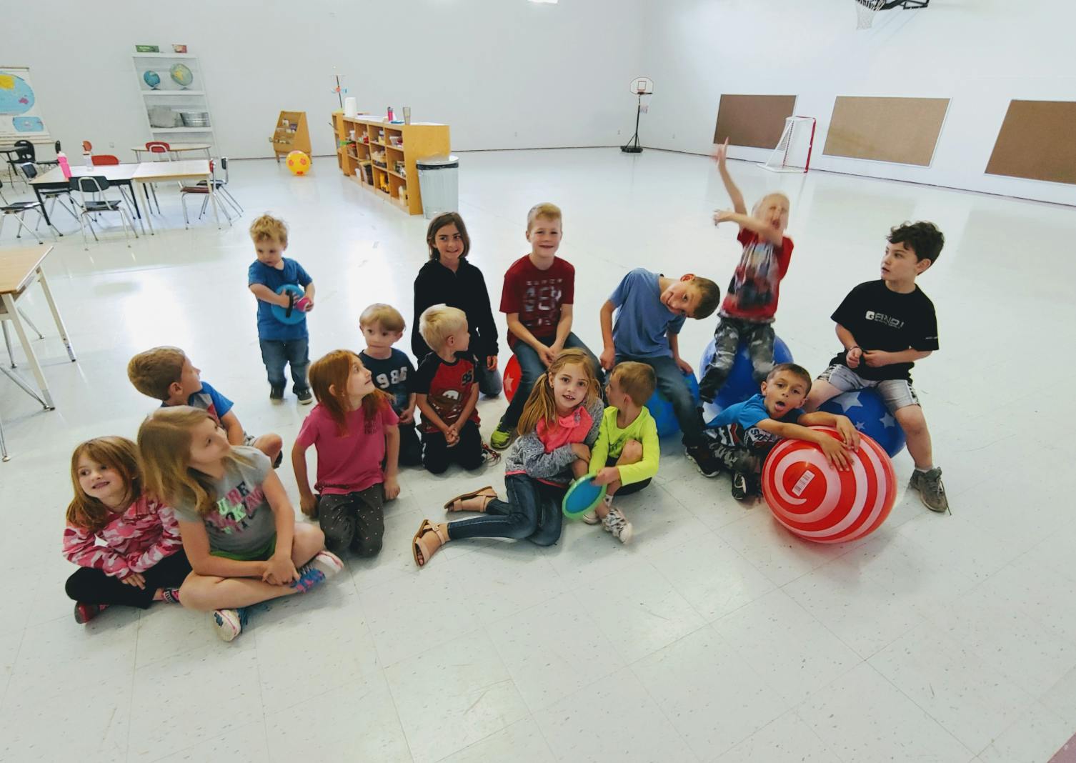 Group of children sitting and standing in a classroom