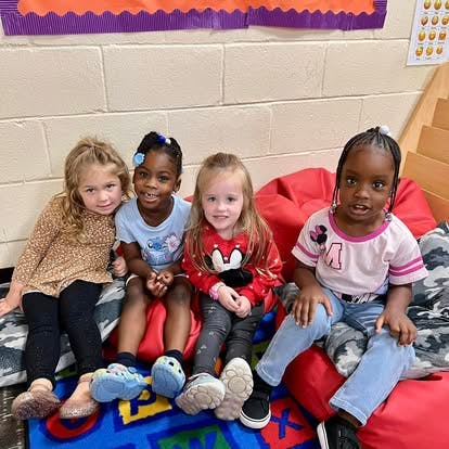 Four children sitting together on beanbags