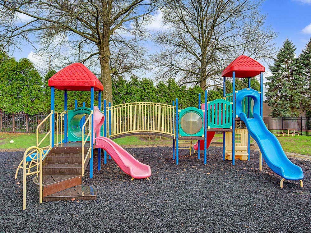 Colorful playground with slides, stairs, and bridge on a rubber ground
