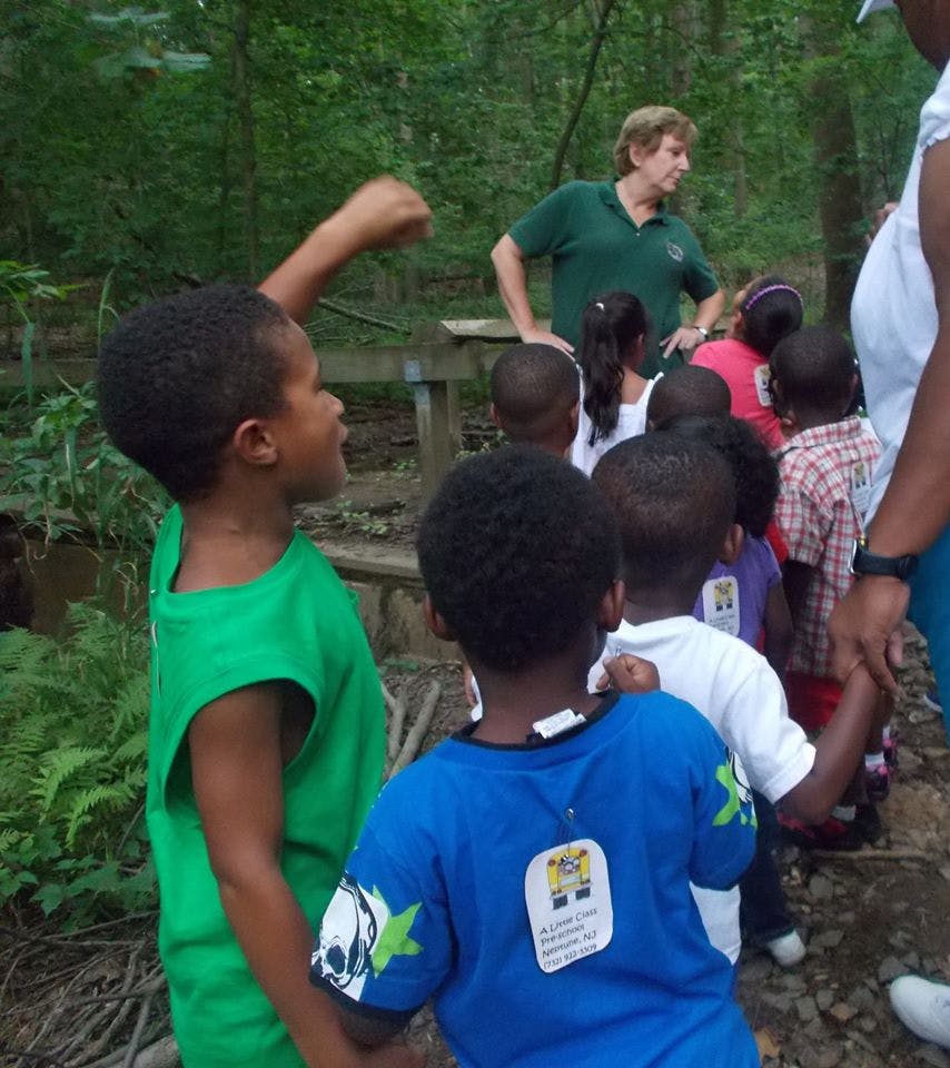 Adult and group of children outdoors