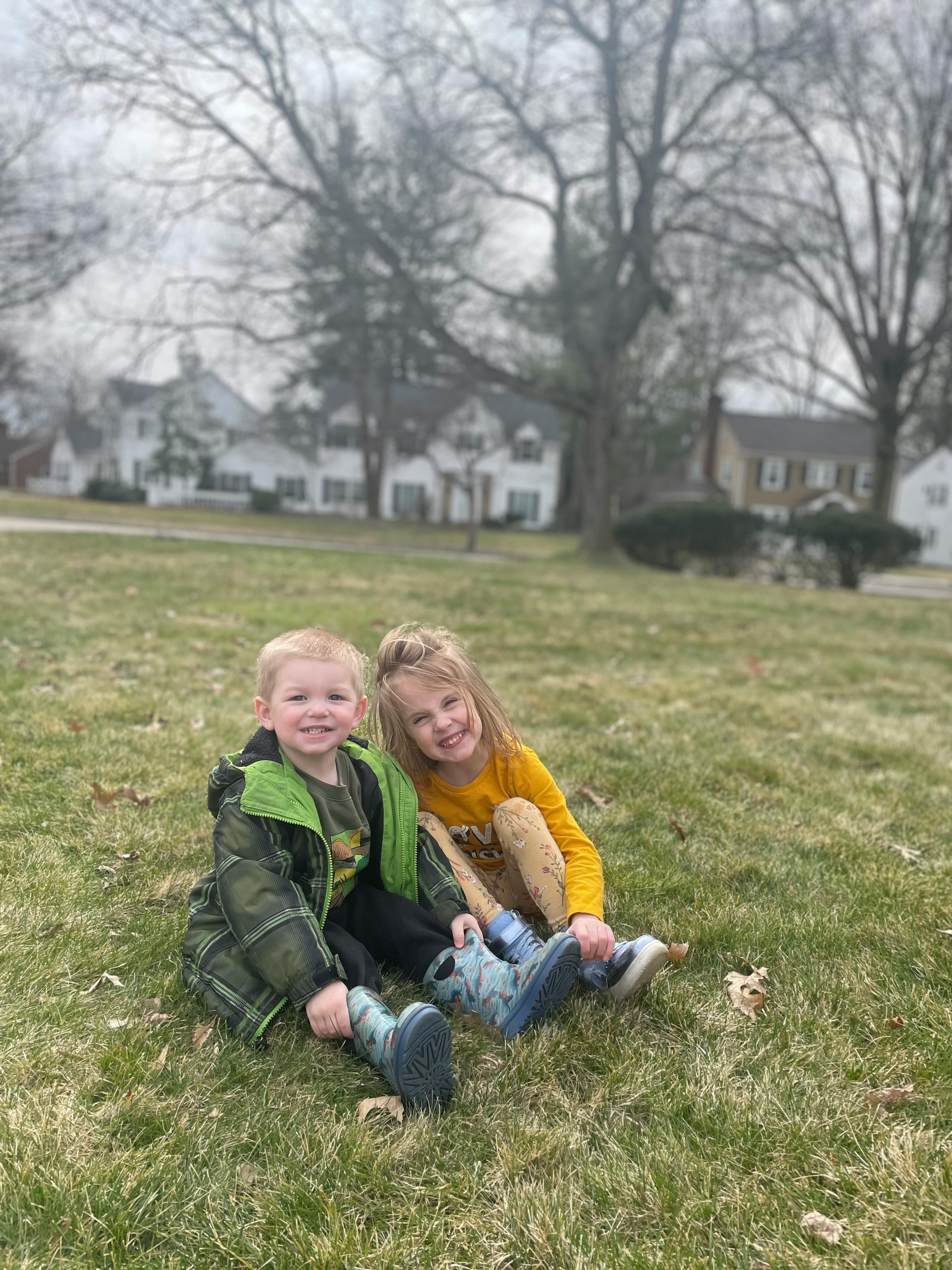 Two children sitting on grass