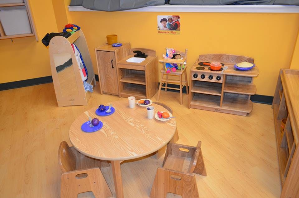 Playroom with child-sized table and chairs, toy kitchen, and high chair