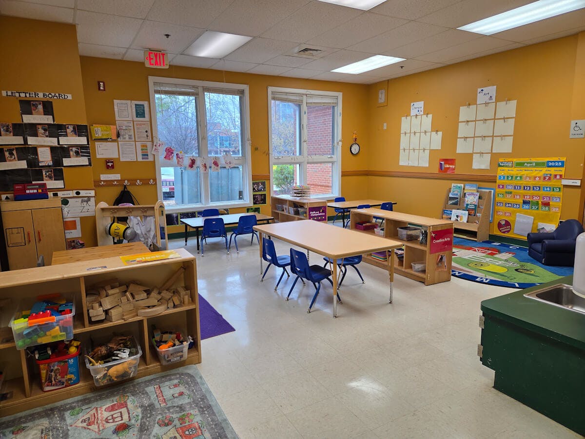 Empty colorful preschool classroom with small tables and chairs