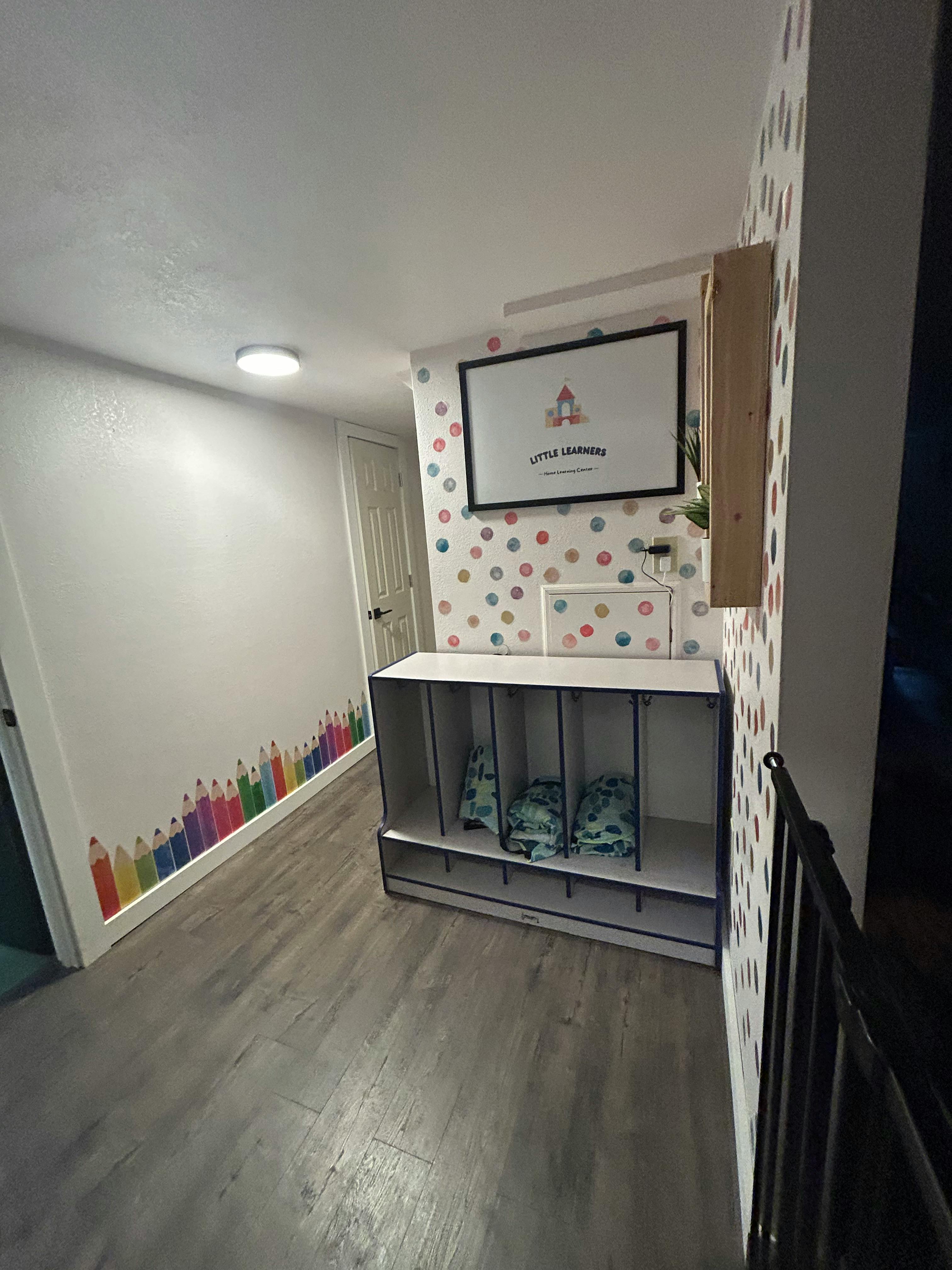Hallway with cubbies, framed art, and pencil wall decals