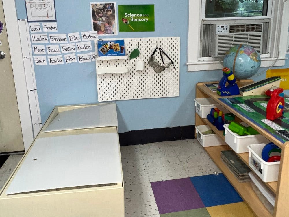 white pegboard on a blue wall with names and various objects around it