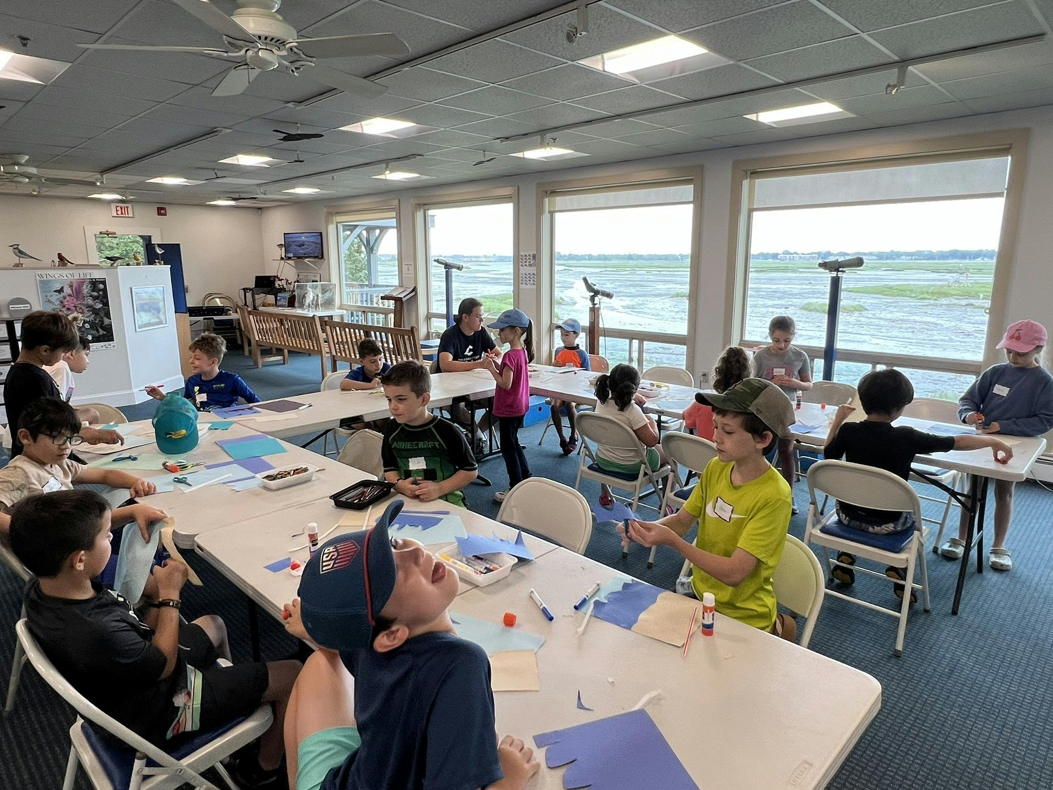 Children and teens sitting at tables in a classroom
