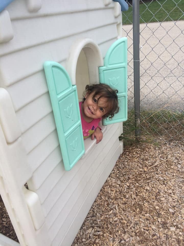 Child looking out of a playhouse window