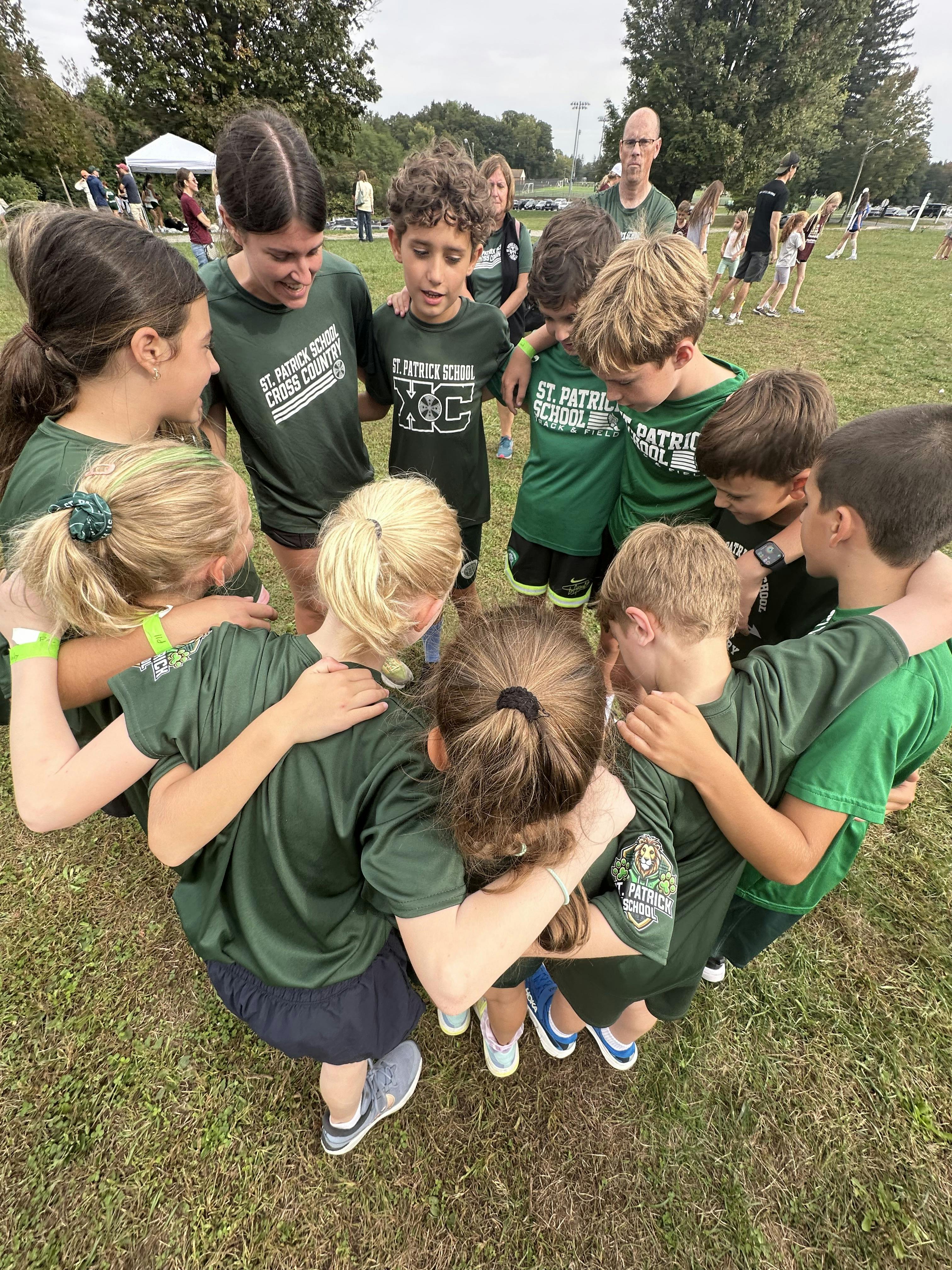 Group of children in green shirts huddled together