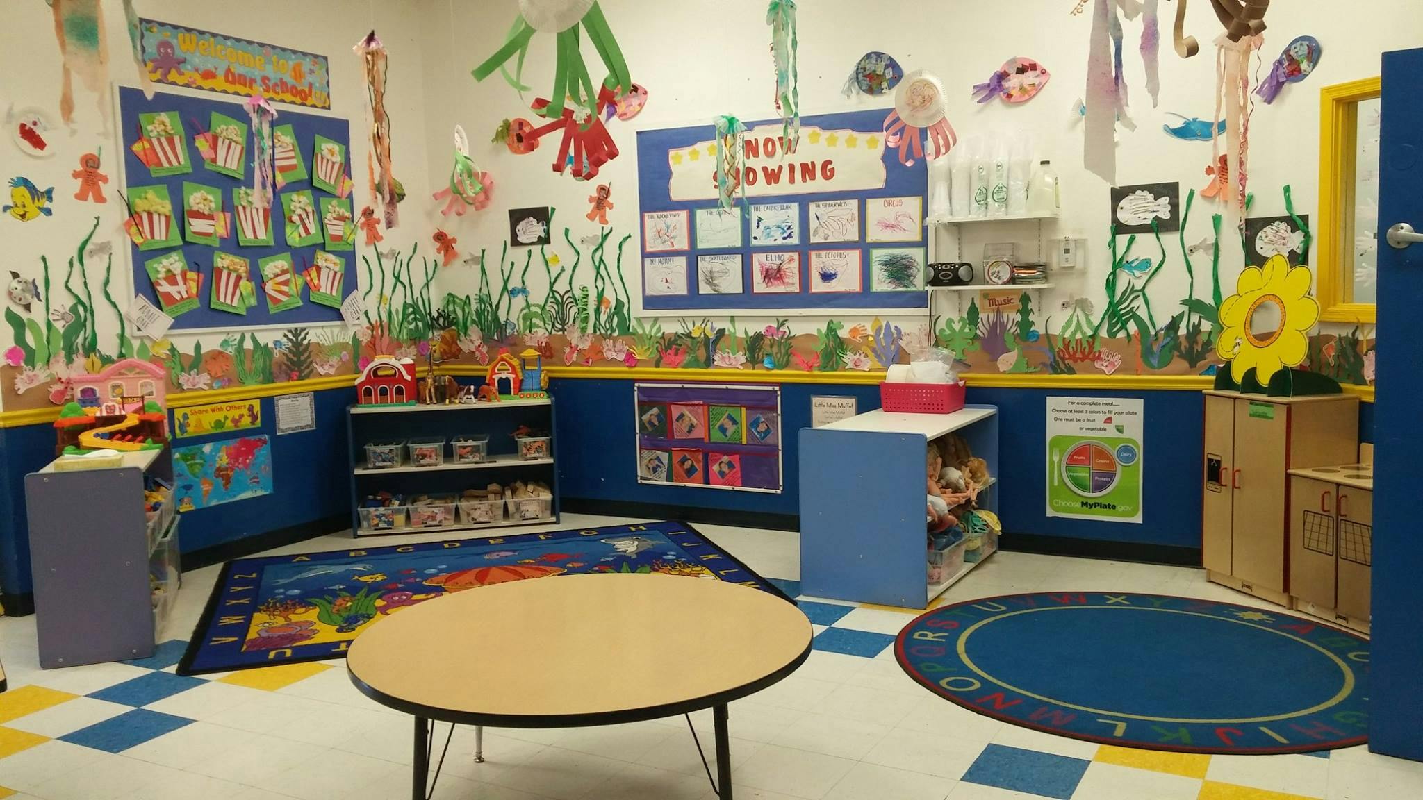 Classroom with colorful decorations, small tables, and rugs