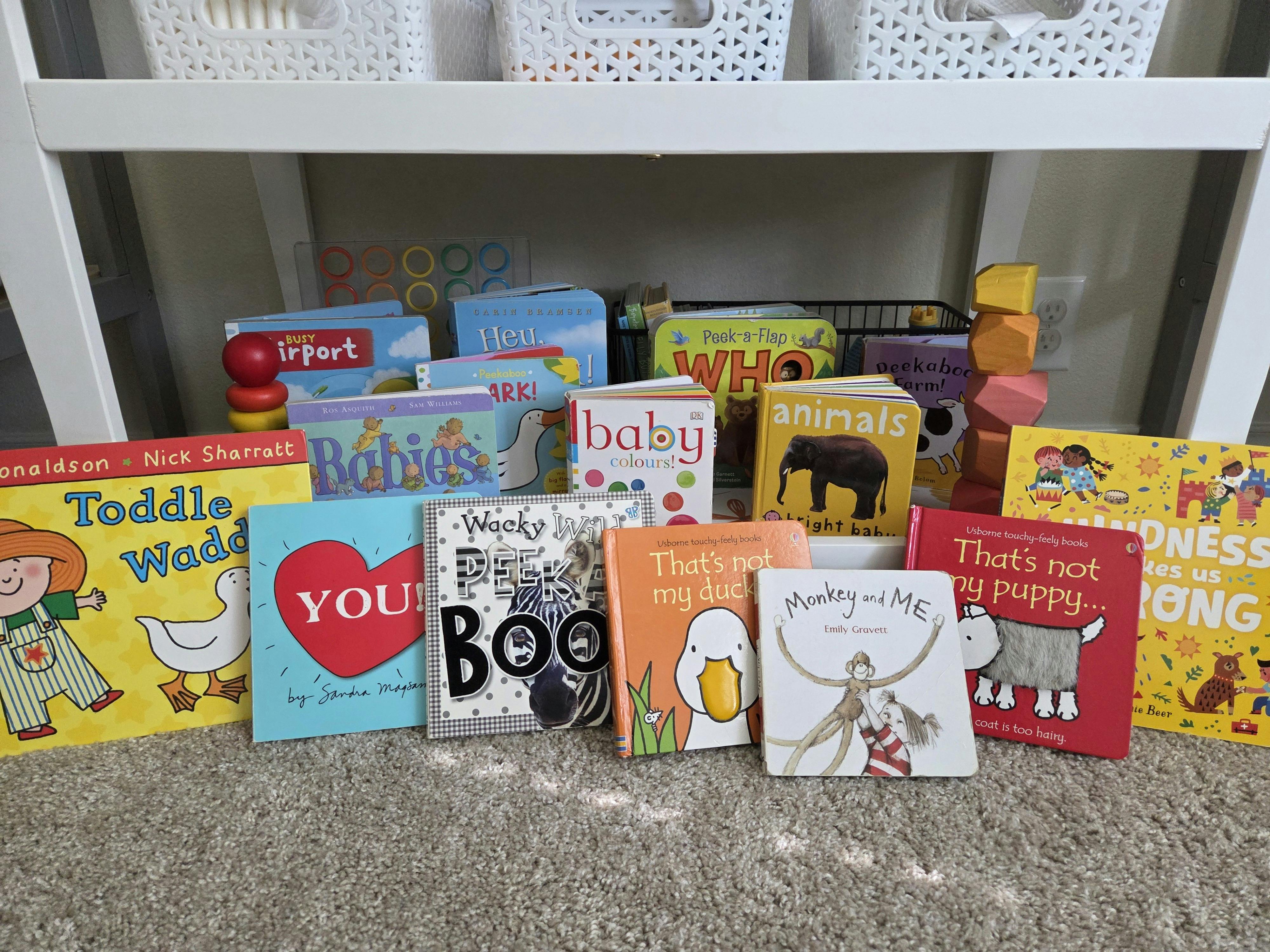 Collection of children's books on a shelf and under a shelf