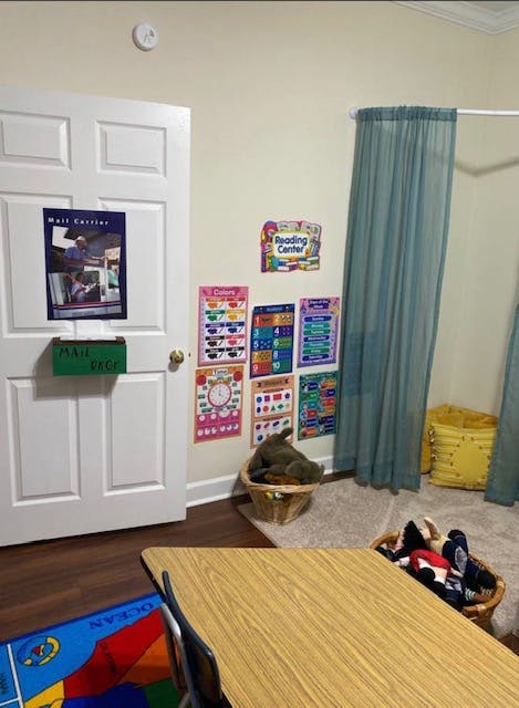 Classroom with posters on the wall, a table, and a rug