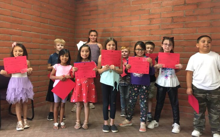 Group of children holding red papers