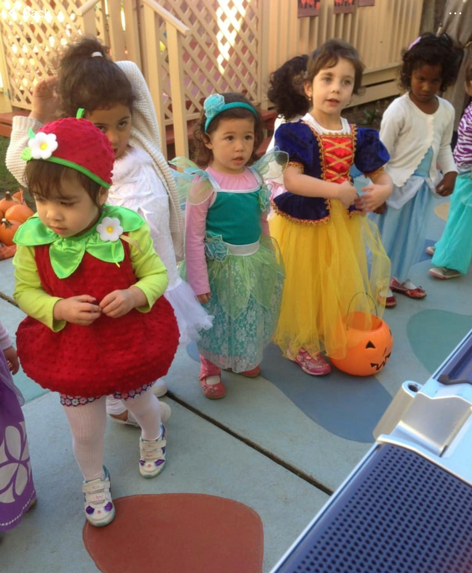Children in costumes, one dressed as a strawberry, another as a princess