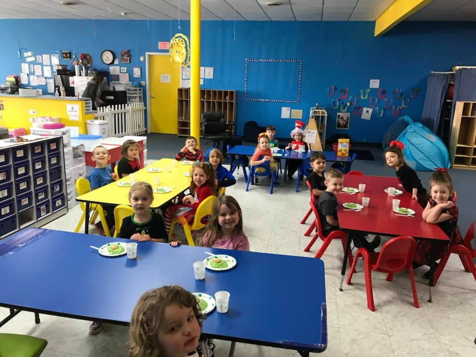 Children sitting at tables in a classroom